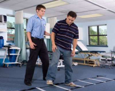 physical therapy professional assiting a patient with a mobility exercise