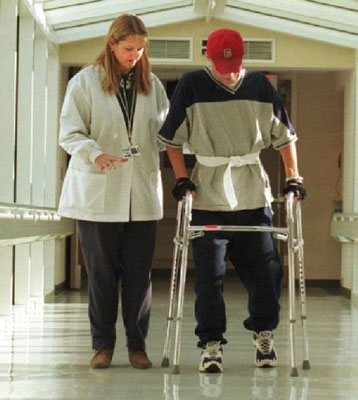 physical therapy professional assiting a patient using a walker