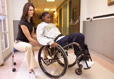 physical therapy professional working with a patient in a wheelchair