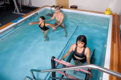 physical therapy professional and patients exercising in a swimming pool