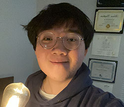 Alexander Le with a lit lightbolb