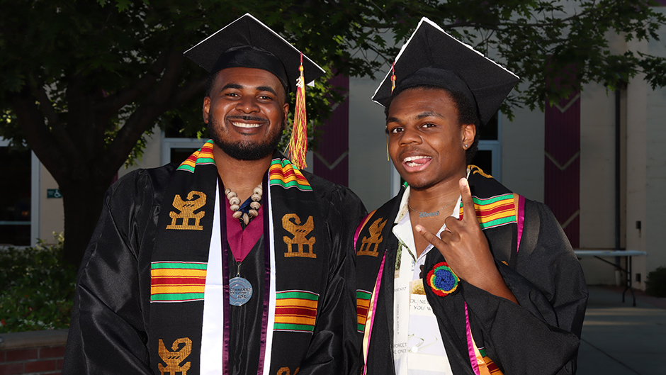 Two SCC graduates posing in commencement regalia