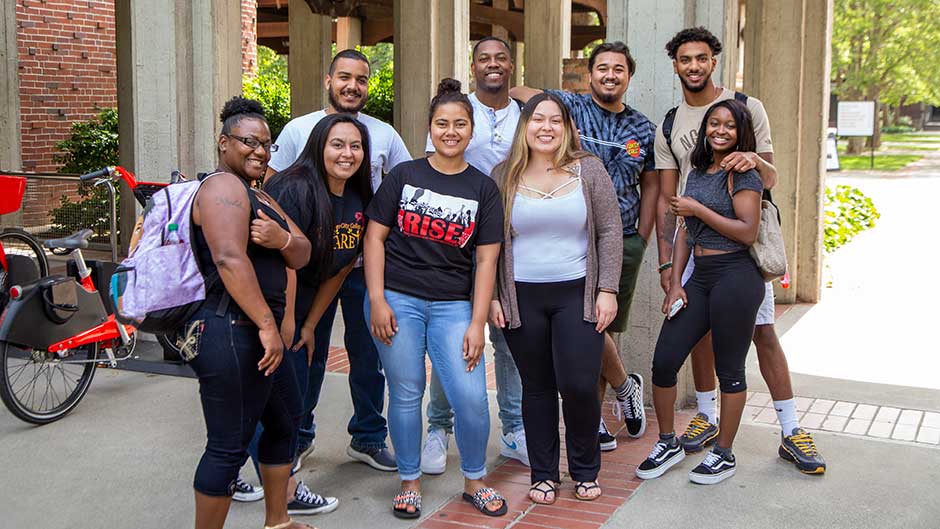 group photo outdoors of eight City Scholars students