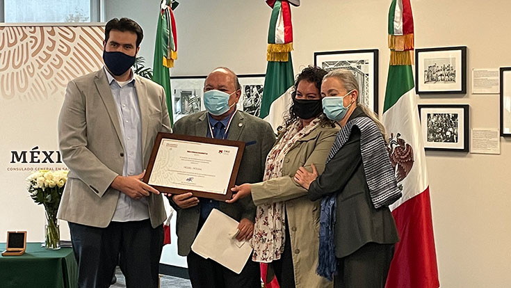 Dr. Miguel Molina posing with award and colleagues