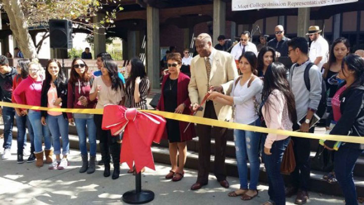 a group of people outdoors at a ribbon-cutting ceremony