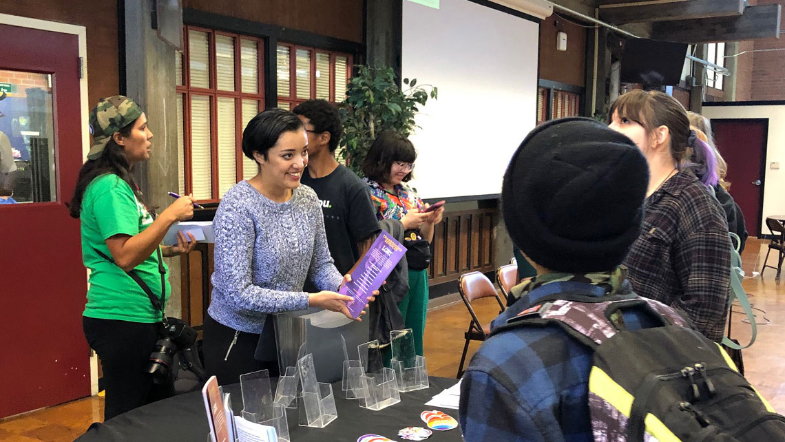 National Coming Out Day resources table with staff and students