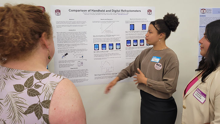 Student presenting her refractometer research on a poster