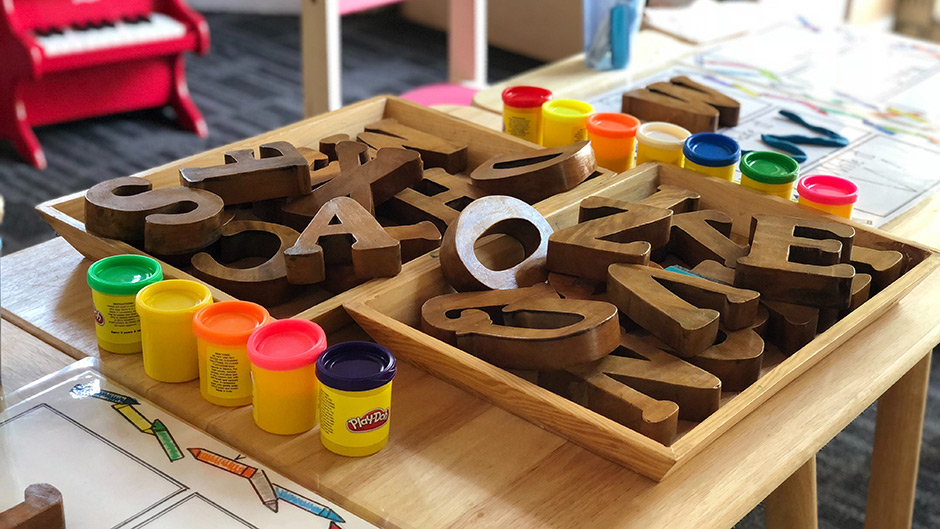 Playdoh and wood letter blocks for children on a table