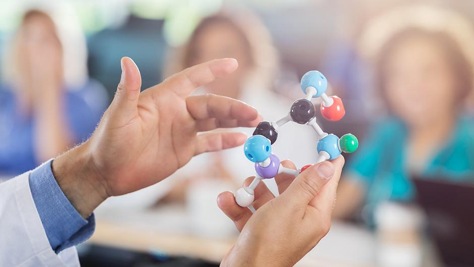 Hands holding a molecule model