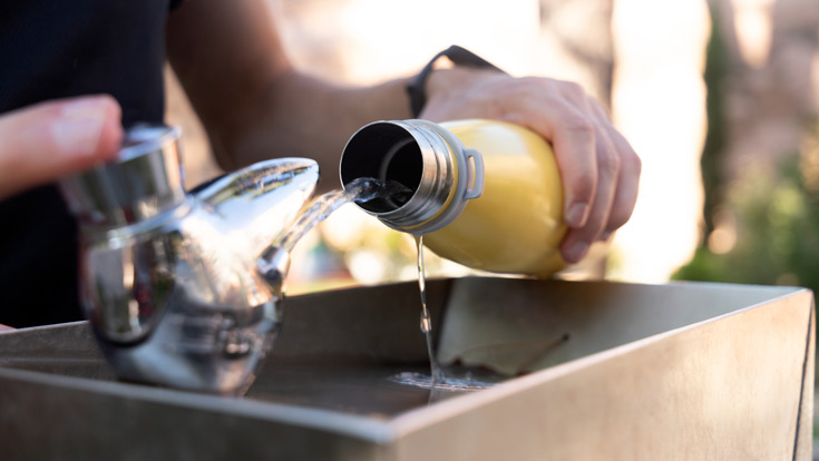 Person filling up water bottle at a water fountain