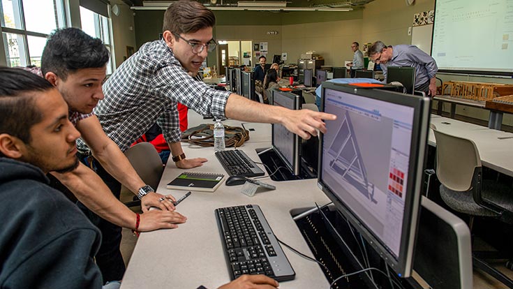 Professor showing students information on a computer screen