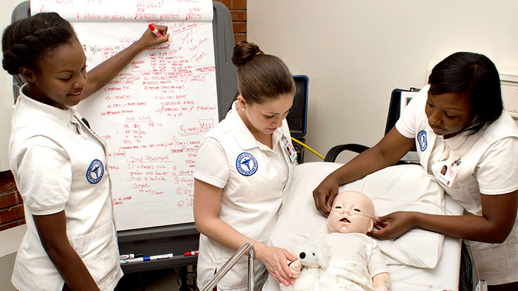 Nursing students working with a dummy